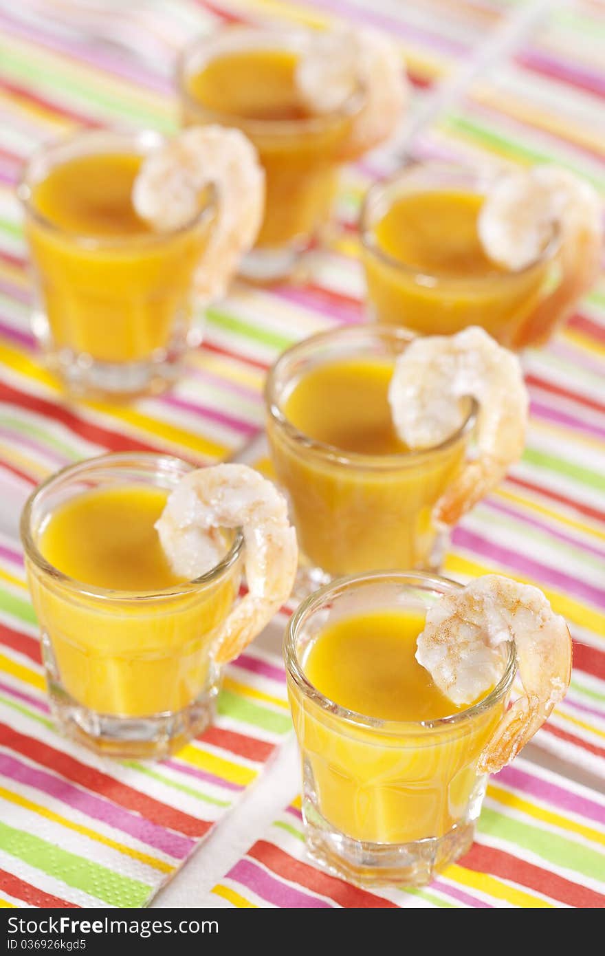 Party snack. Pumpkin soup with orange juice in the glasses and grilled tiger prawns. Party snack. Pumpkin soup with orange juice in the glasses and grilled tiger prawns