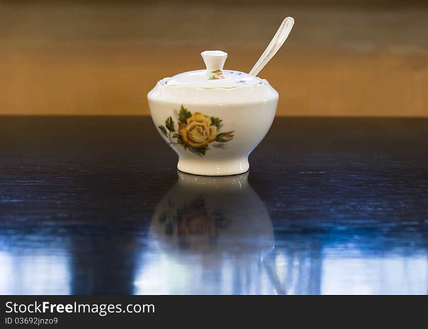 Vintage style Chinese porcelain sugar bowl on table in retro cafe. Vintage style Chinese porcelain sugar bowl on table in retro cafe.