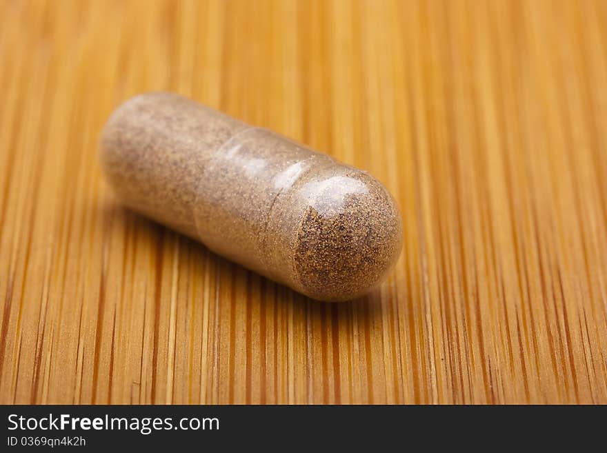 Medical pill against diseases on a wooden table.