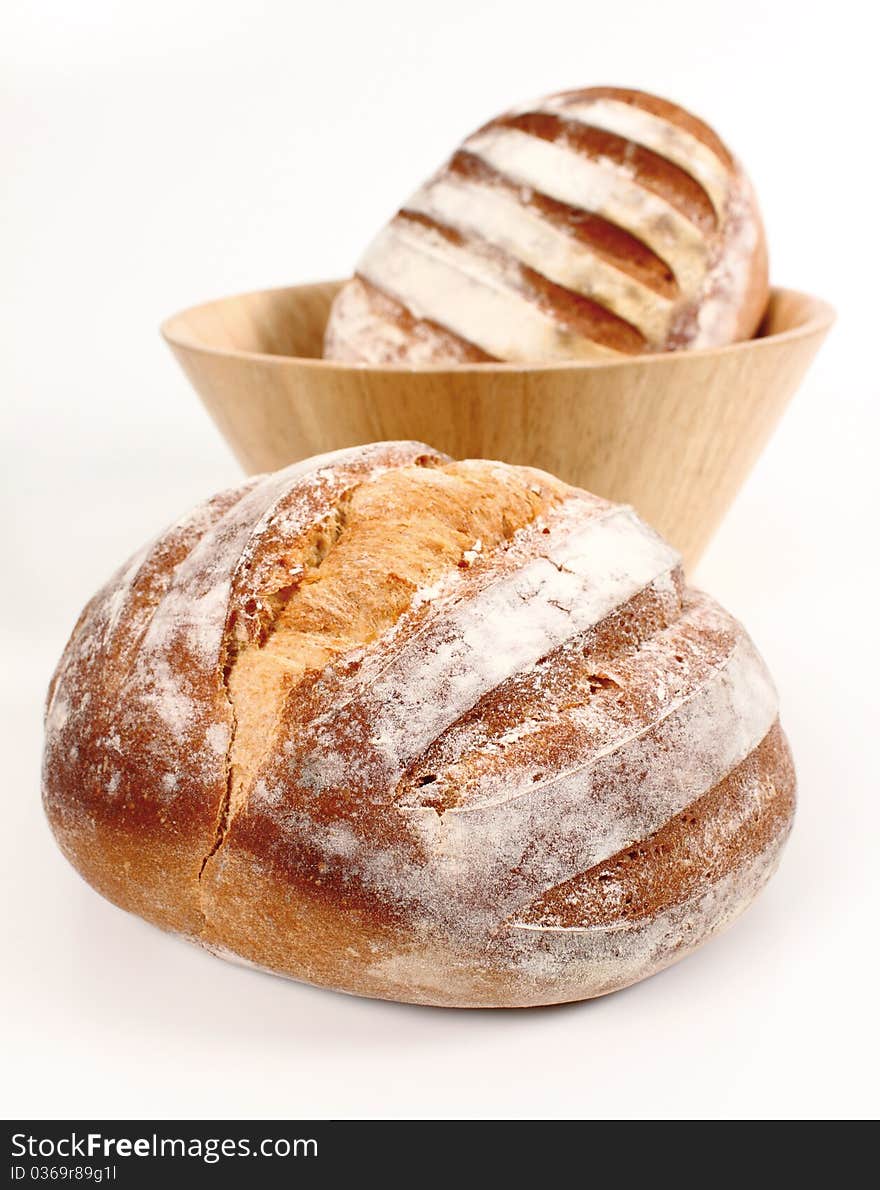 Fresh bread in the foreground and another in a bowl