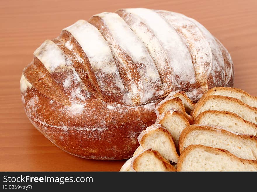 Fresh bread in the foreground on wooden background