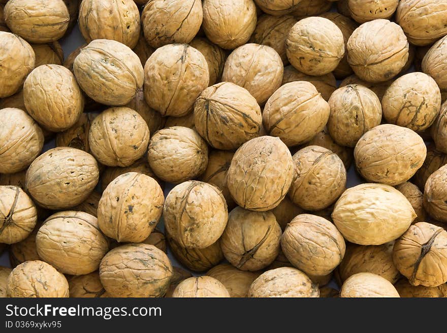 Closeup of brown raw walnuts background