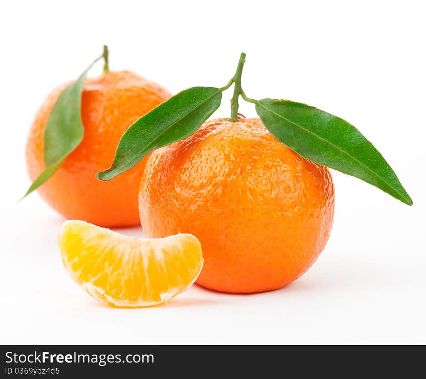 Tangerines with leaves and slices on white background