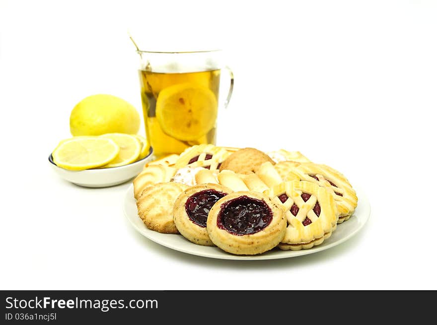 Cookies on a plate with lemon tea on a white background