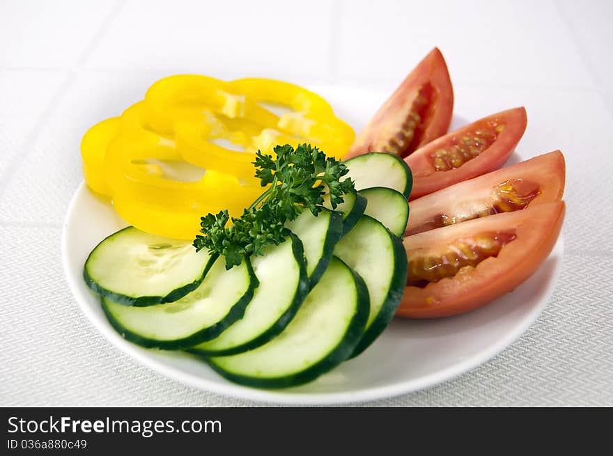 Colored raw vegetables for salad in plate on a table