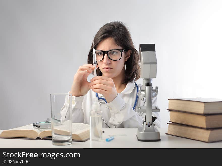 Young scientist examining some substances in a laboratory. Young scientist examining some substances in a laboratory