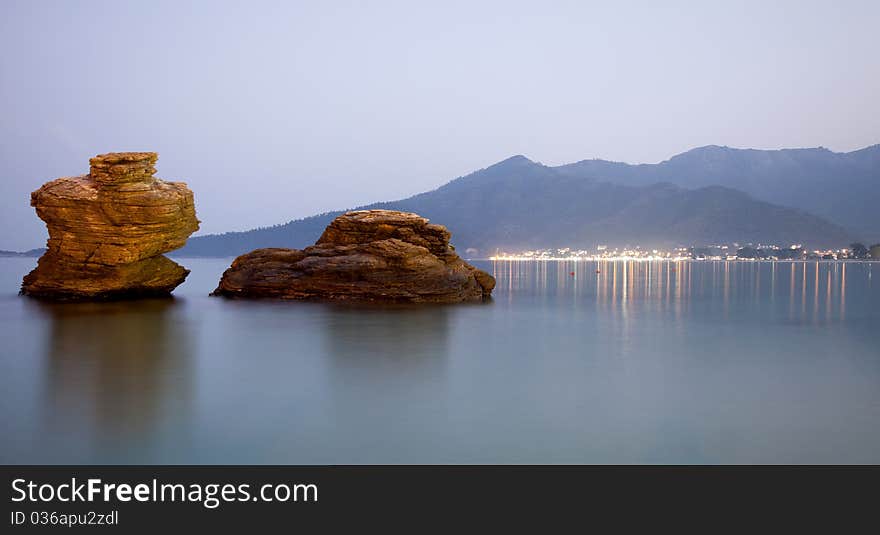 Two stones in the sea at dusk