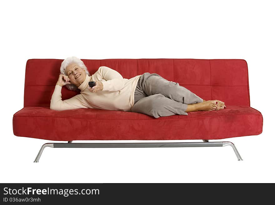 Elderly woman on the sofa with television remote control