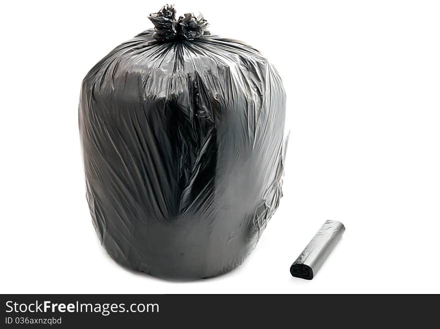 Tied black garbage bag isolated on a white background.