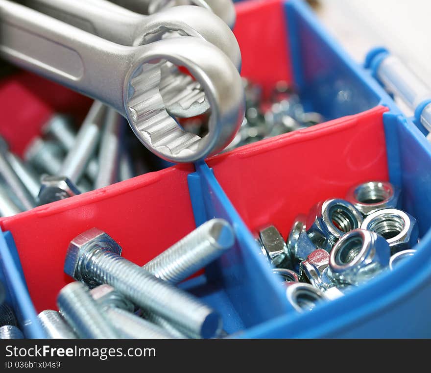 A set of spanners in front of toolbox of bolts and nuts. A set of spanners in front of toolbox of bolts and nuts