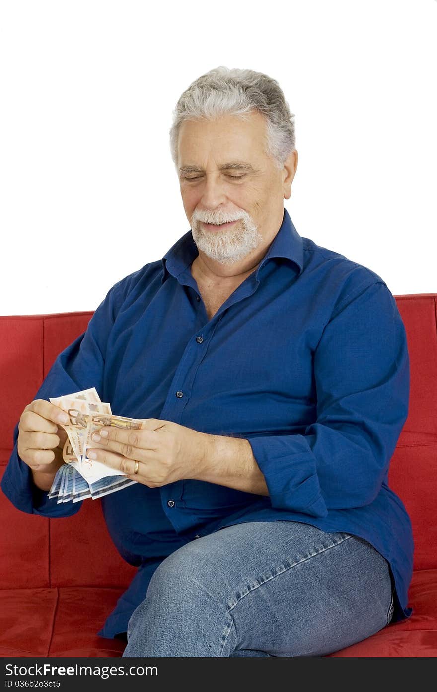 Elderly man on the couch with money in hand in a white background