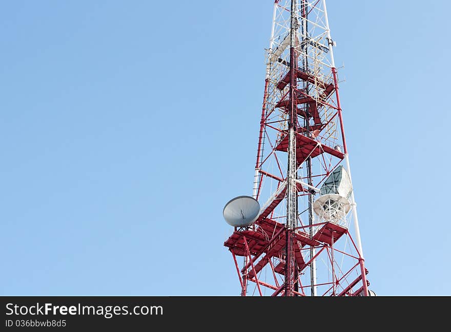 Telecommunication tower over blue cloudless sky