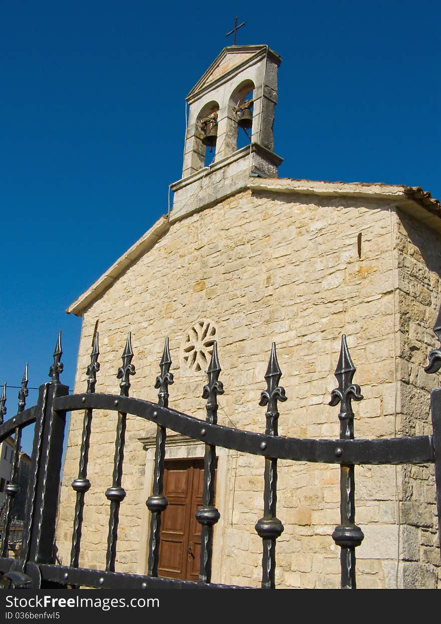 Village chapel against clear blue sky: wrought iron fence, church courtyard, wooden door and stone brick religious building

Location: Vizinada in Istria, Croatia, Europe

*RAW format available at request. Village chapel against clear blue sky: wrought iron fence, church courtyard, wooden door and stone brick religious building

Location: Vizinada in Istria, Croatia, Europe

*RAW format available at request