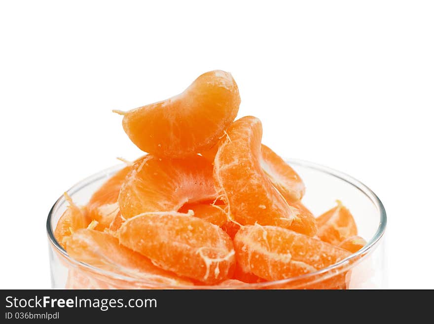 A sliced mandarin in the glass form on white