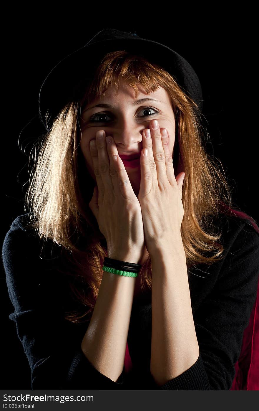 Blonde girl deforms the face with his own hands on black background