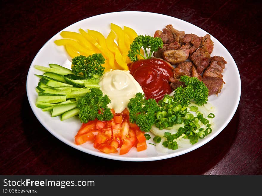 Appetizing meat and vegetable allsorts with sauces and greens