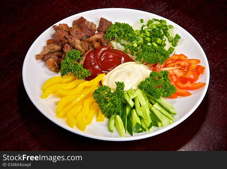 Appetizing meat and vegetable allsorts with sauces and greens