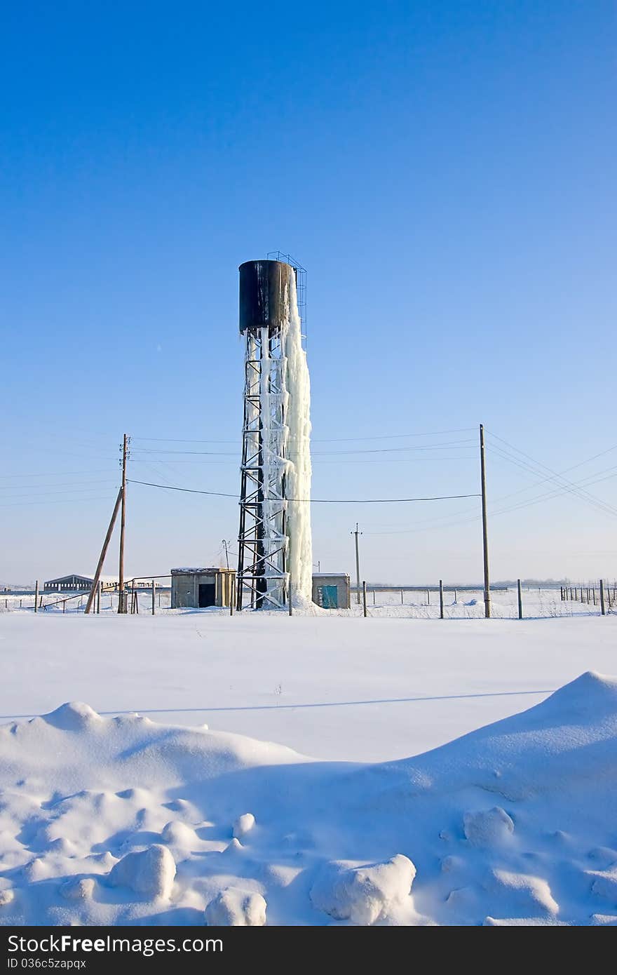 View of  frozen beneath  ice water tower in  winter in  field. View of  frozen beneath  ice water tower in  winter in  field.