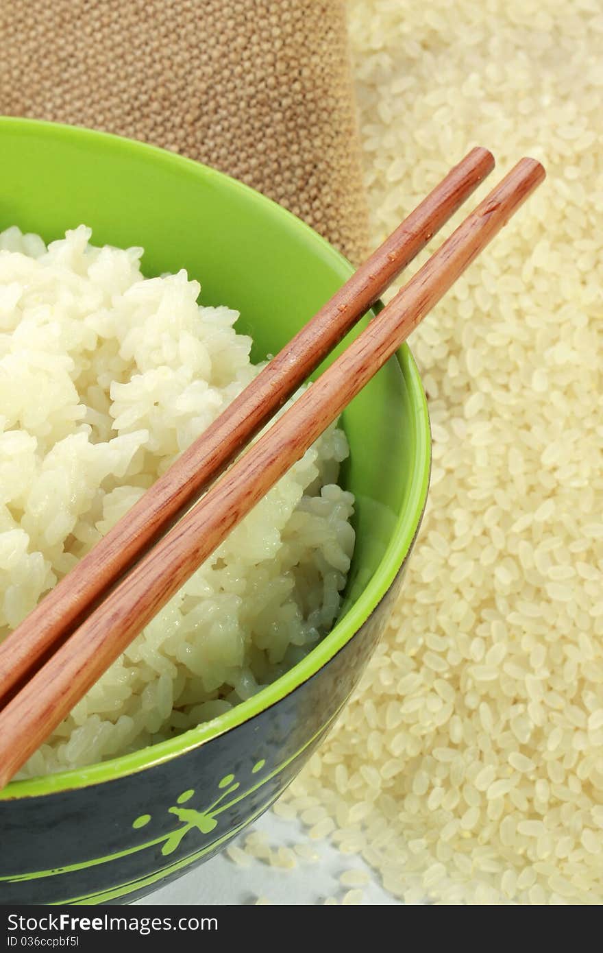 A bowl of rice and a pile of uncooked rice