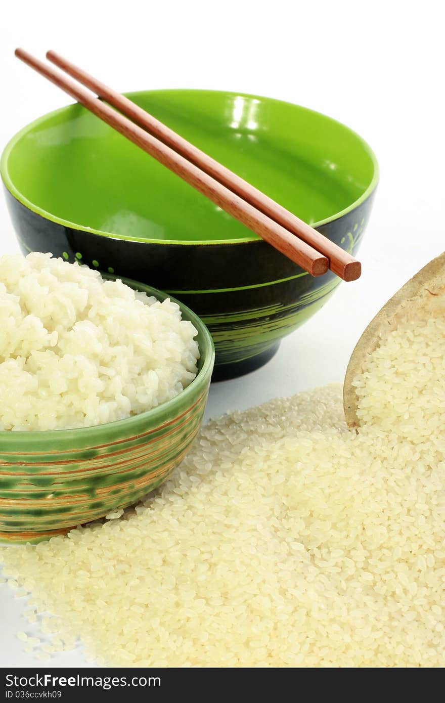 A bowl of rice and a pile of uncooked rice