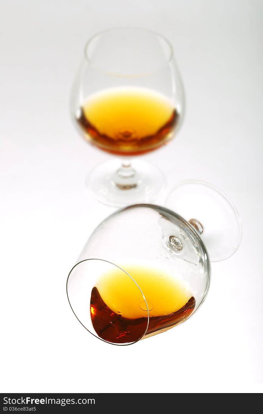 Glass of cognac over white background