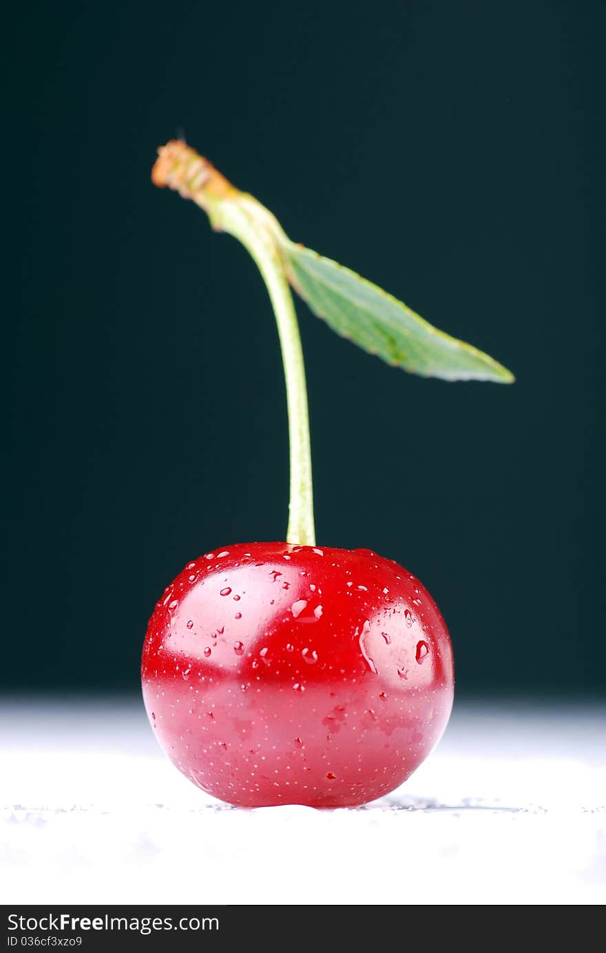 A single cherry against dark background