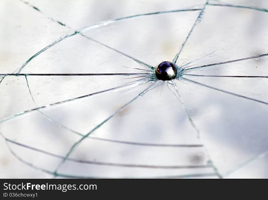 Glass broken with a steel bullet in the form of a ball. Glass broken with a steel bullet in the form of a ball