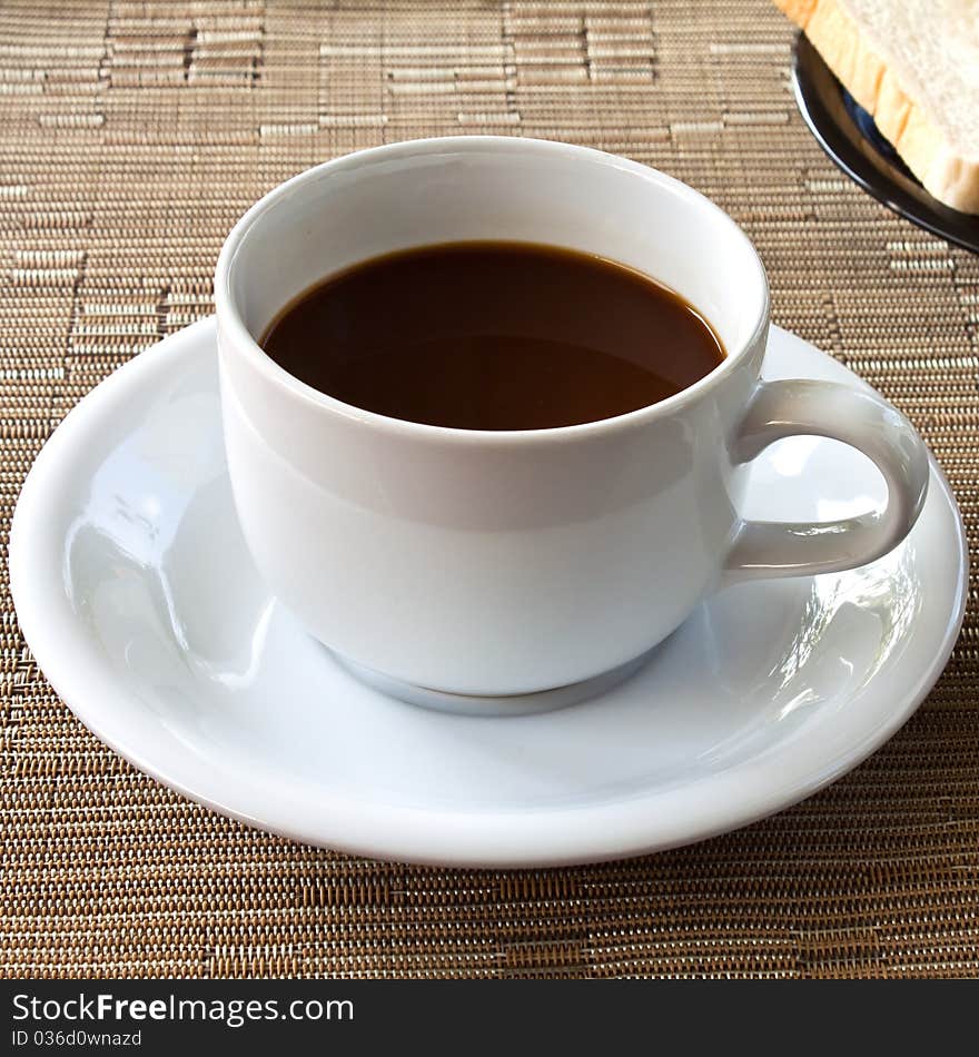 Cup of coffee and bread on table