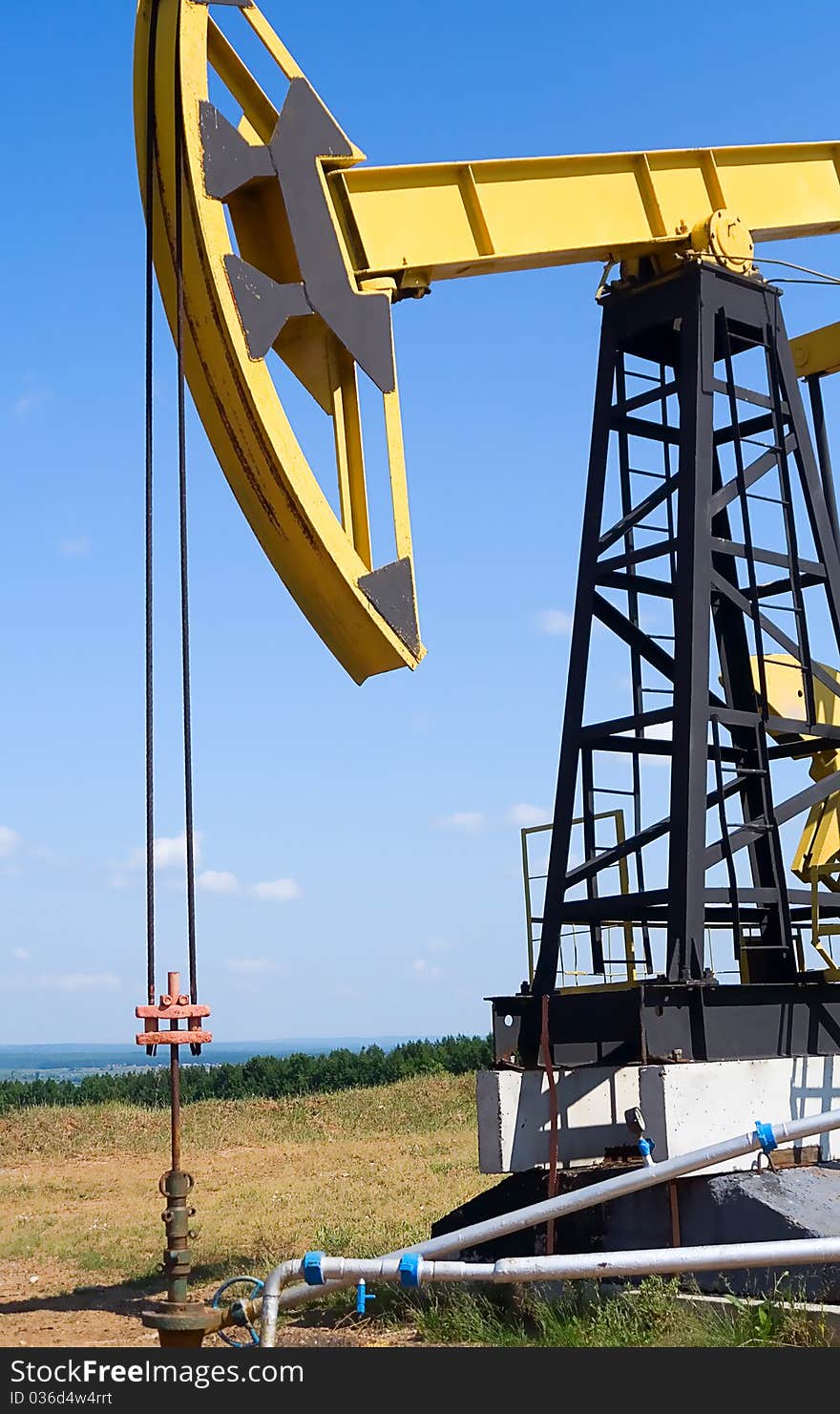 Oilfield Pump Jack with a bright blue sky and clouds. Oilfield Pump Jack with a bright blue sky and clouds