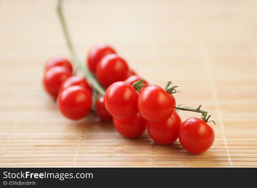 Branch or cherry tomatoes on wooden pad