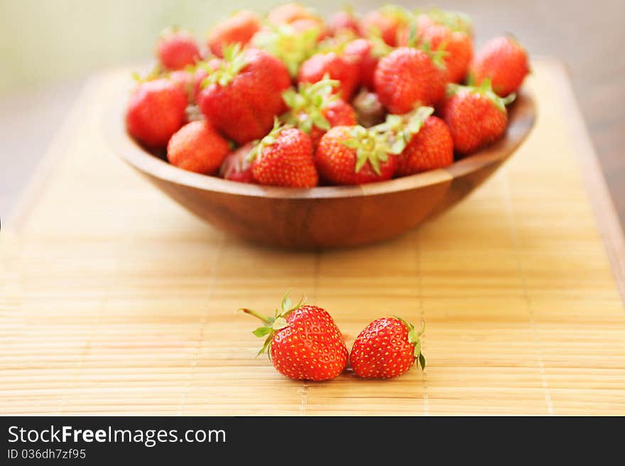 Fresh ripe strawberries in wooden bowl