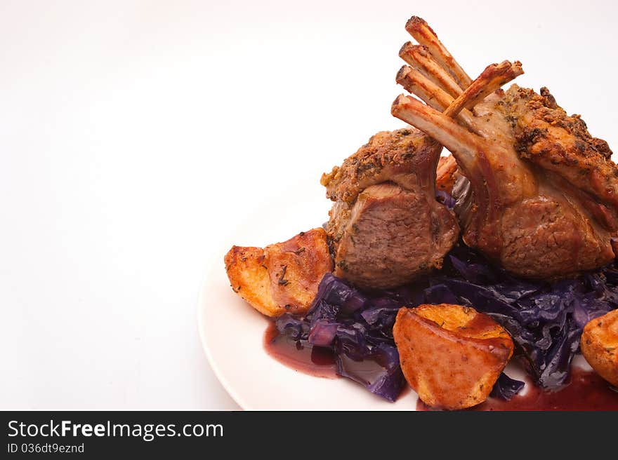 French dressed rack of lamb plated with potatoes and red cabbage. French dressed rack of lamb plated with potatoes and red cabbage