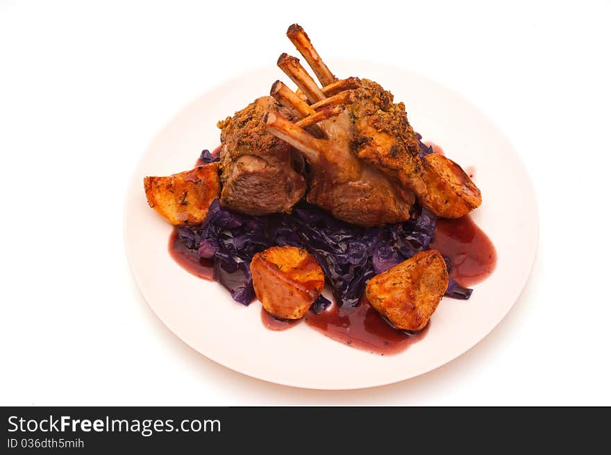 French dressed rack of lamb plated with potatoes and red cabbage. French dressed rack of lamb plated with potatoes and red cabbage