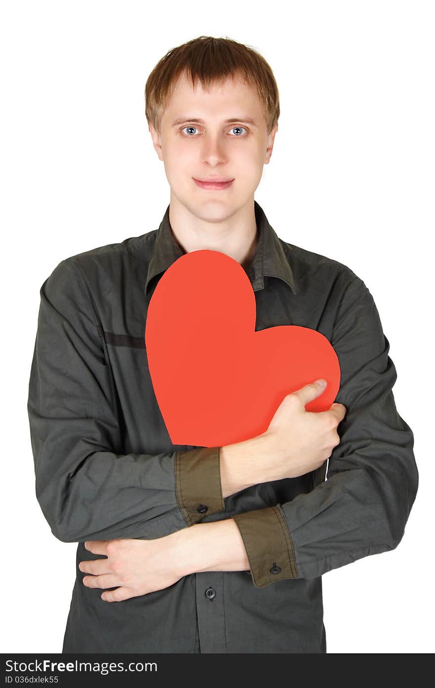 Young caucasian man holding red paper heart and smiling, decloration of love, isolated