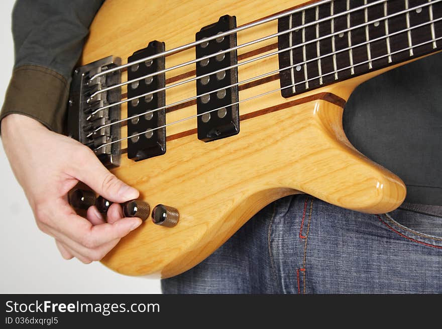 Man tuning bass guitar closeup