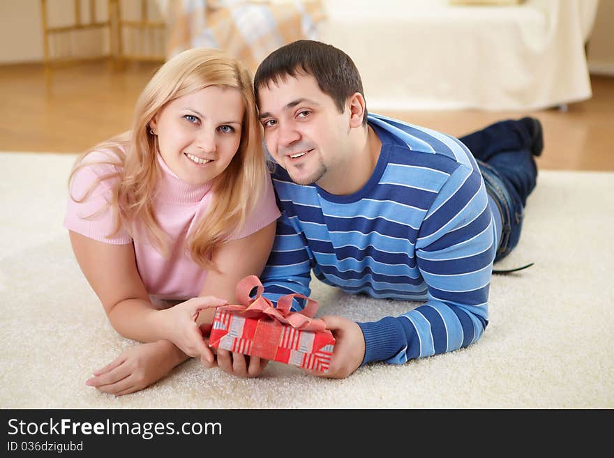 Young beautiful couple together with a present. Young beautiful couple together with a present