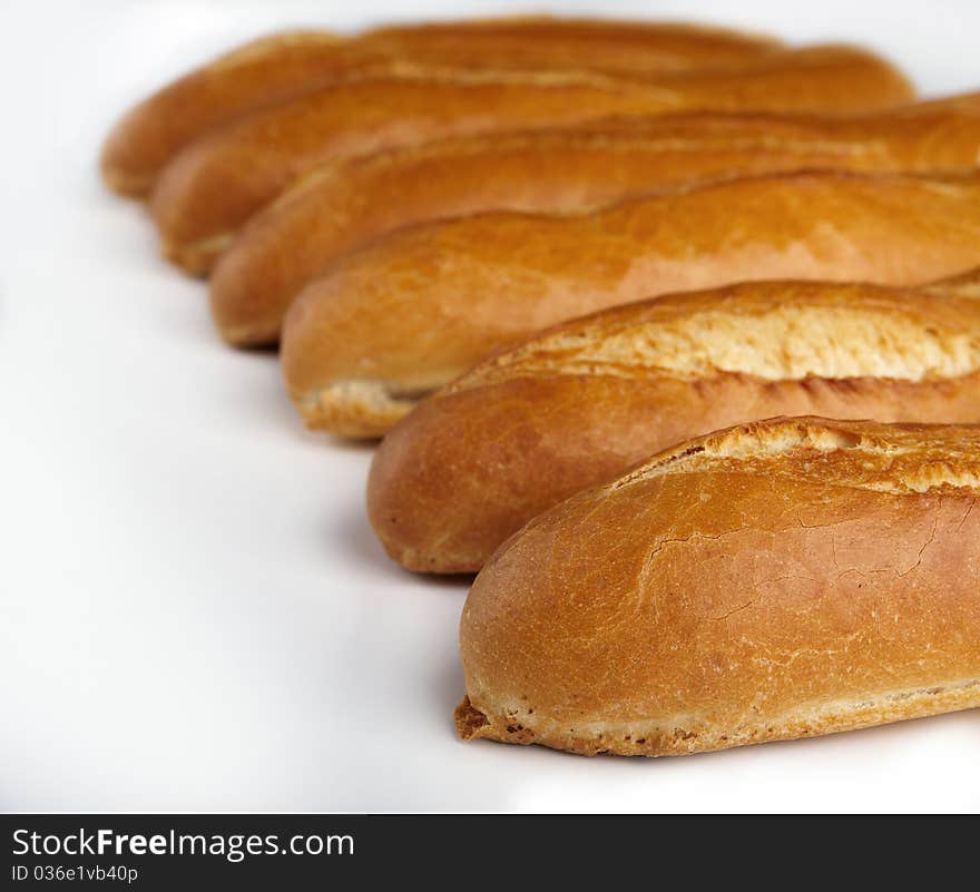 Loaf of white bread are in a row on a white background. Loaf of white bread are in a row on a white background