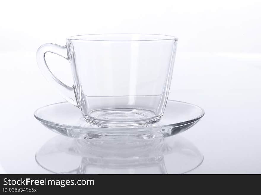 Empty transparent glass cup and saucer.