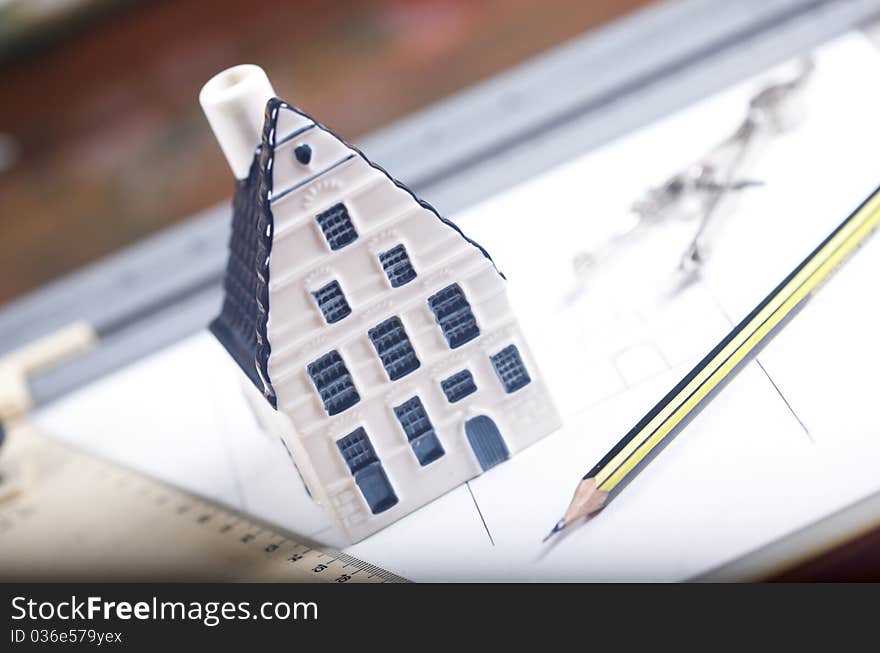 Breadboard model of a house and paper with a pencil