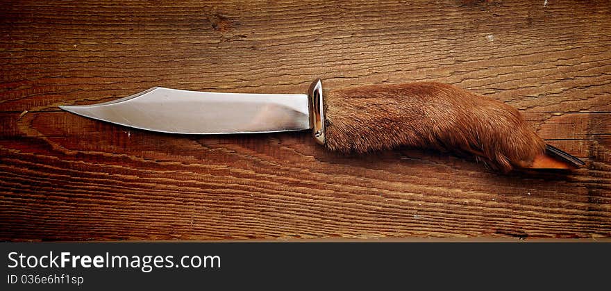 Hunting knife on wood background