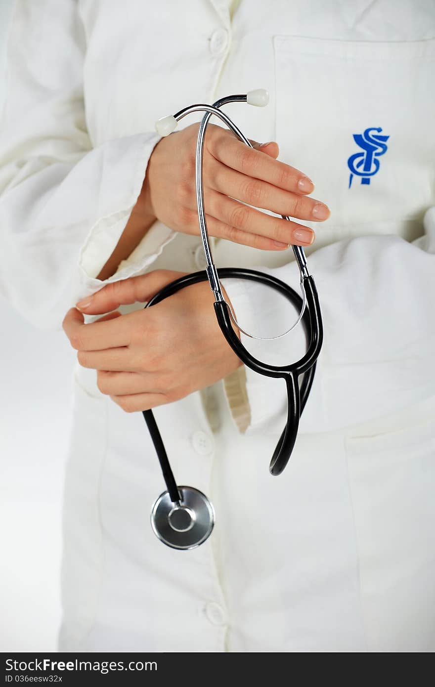 Nurse standing and holding her stethoscope in her hands. Nurse standing and holding her stethoscope in her hands