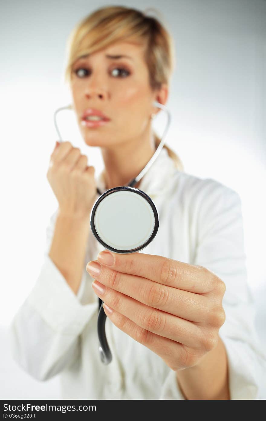 Nurse with the stethoscope in her hand looking worried. Nurse with the stethoscope in her hand looking worried