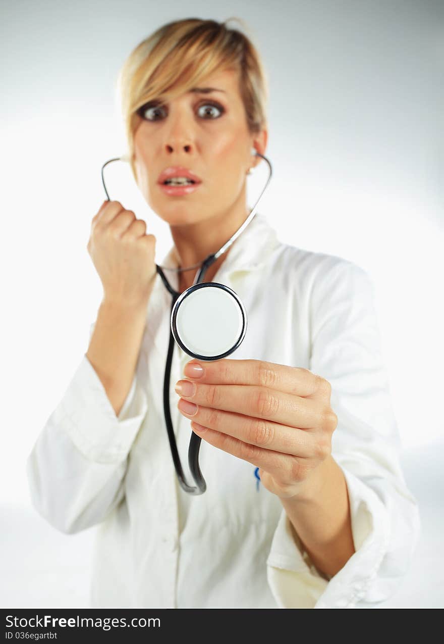 Nurse with the stethoscope in her hand looking scared. Nurse with the stethoscope in her hand looking scared