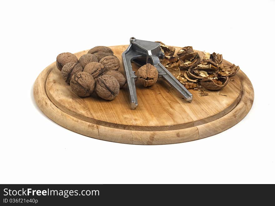 Nutcracker with nuts on a wooden plate