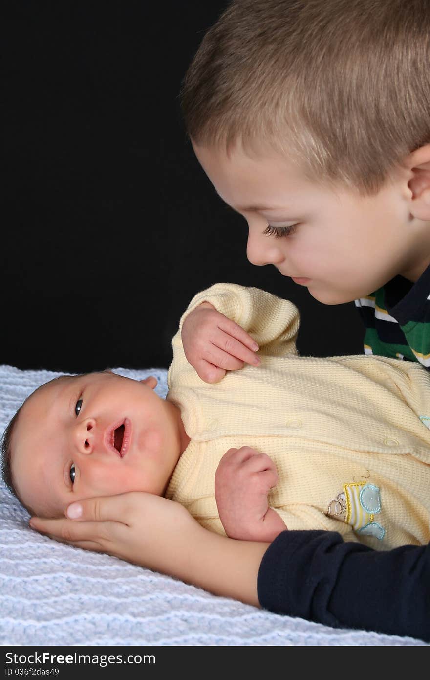 Blond boy looking at his newborn baby brother. Blond boy looking at his newborn baby brother