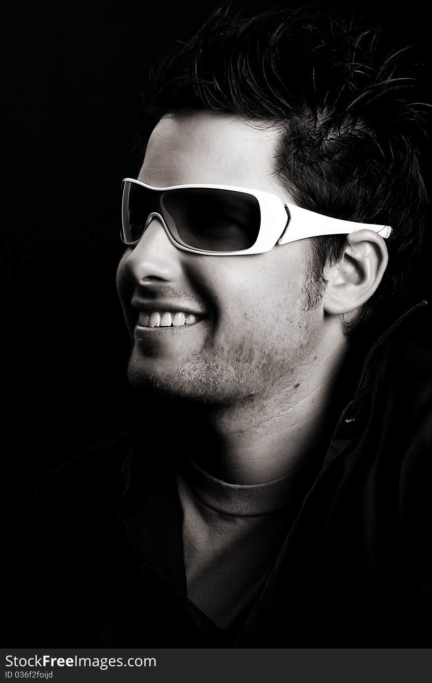 Attractive male wearing sunglasses against black background