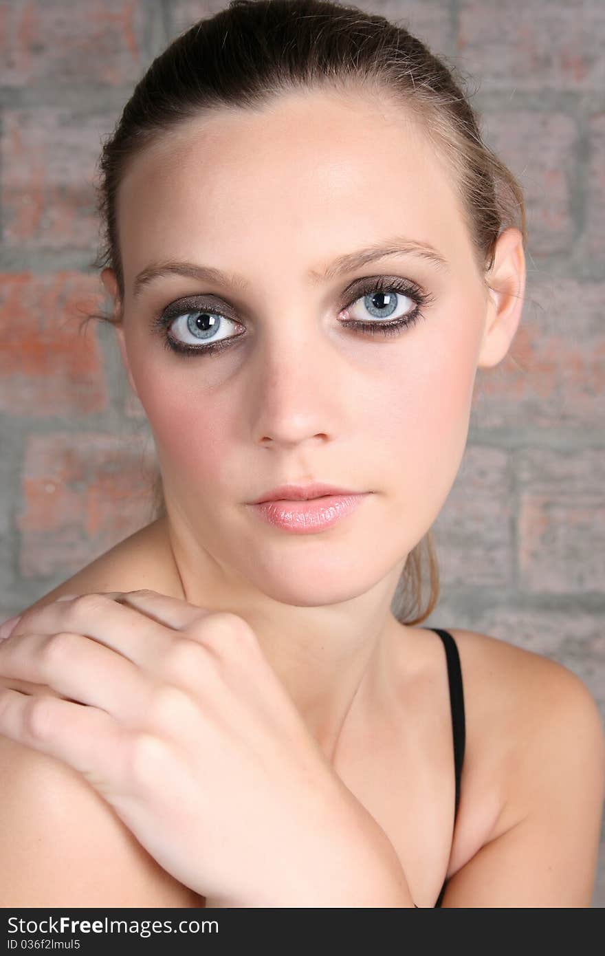 Natural portrait of blue eyed model against brick wall. Natural portrait of blue eyed model against brick wall