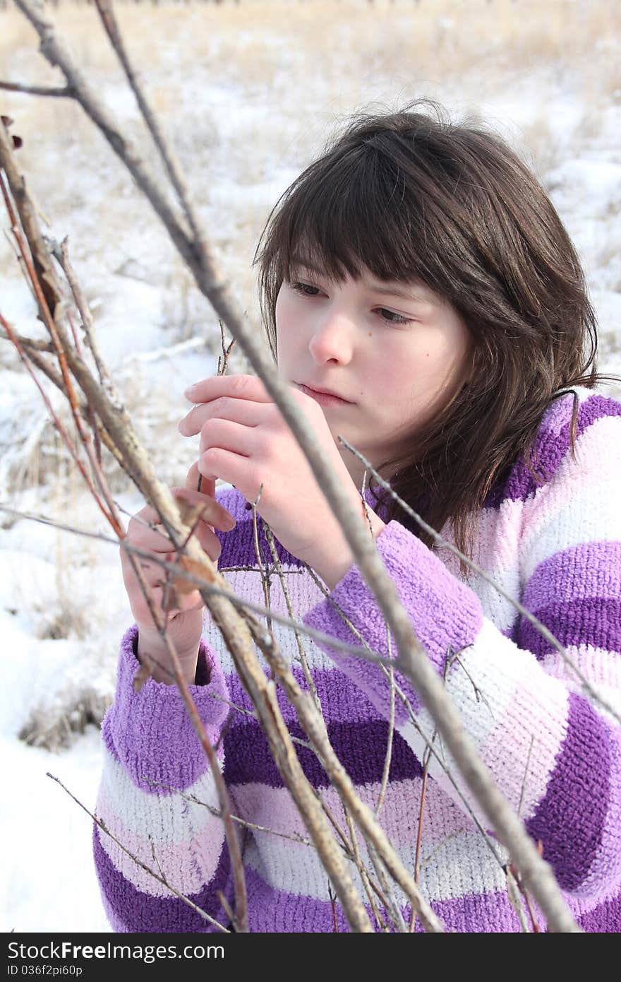 Young brunette teen playing in the field after the snowfall. Young brunette teen playing in the field after the snowfall