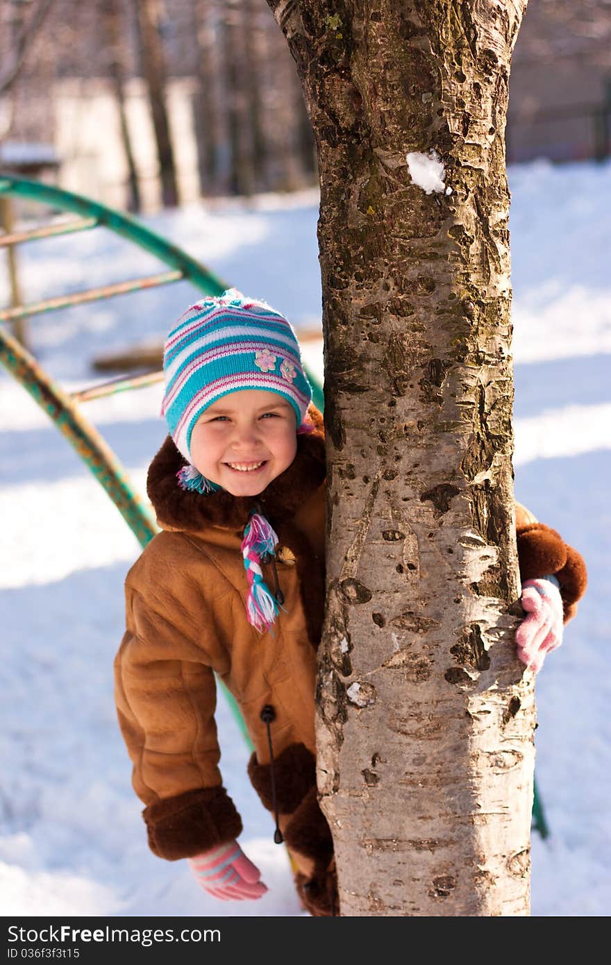 Beautiful Girl Playing Near The Tree In Winter