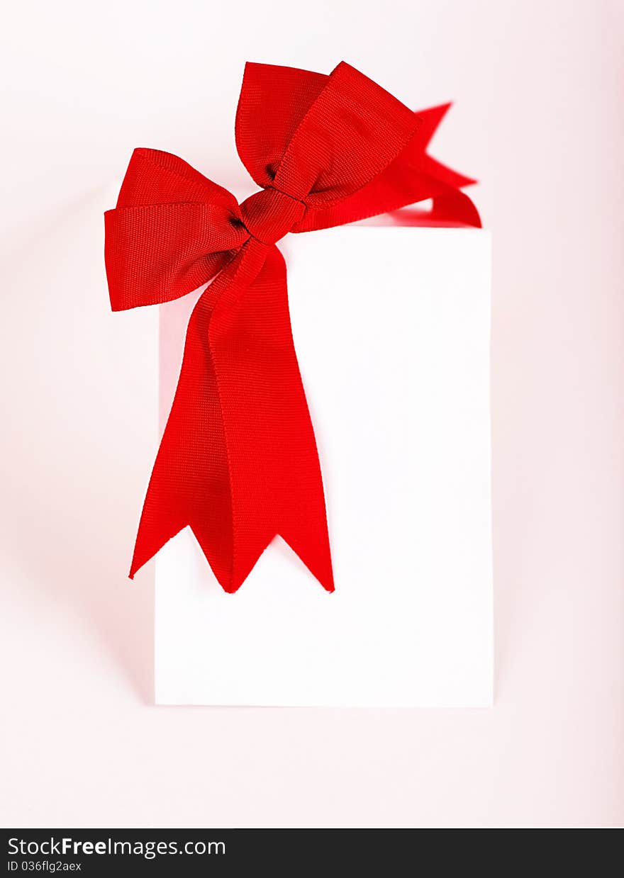 Beautiful red bow over blank greeting card, holiday concept. Beautiful red bow over blank greeting card, holiday concept